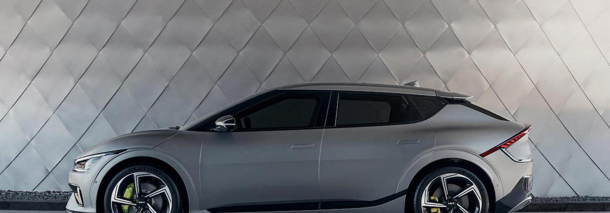 Kia EV6 parked in front of a shiny grey wall.