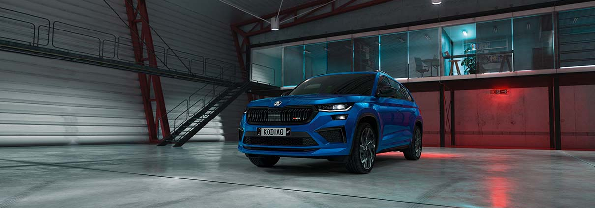 Blue ŠKODA KODIAQ RS parked in a modern industrial building.
