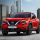 Red Nissan Juke crossover SUV with a futuristic city in the background.